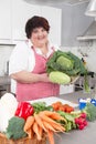 Overweight woman holding salads - cooking at home.