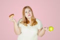 Overweight woman holds donuts and apple fruit Royalty Free Stock Photo