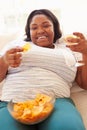 Overweight Woman At Home Eating Chips And Drinking Wine Royalty Free Stock Photo