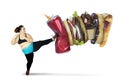 Overweight woman kicking soft drink and fast foods Royalty Free Stock Photo