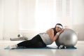 Overweight woman leaning on fit ball instead of training at gym Royalty Free Stock Photo