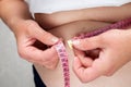 Overweight woman measuring her waist with a tape measure Royalty Free Stock Photo