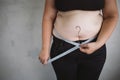 Overweight woman measuring waist with measure tape Royalty Free Stock Photo