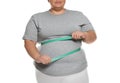 Overweight woman measuring waist with tape on white background Royalty Free Stock Photo