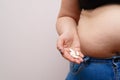Overweight woman with obese belly taking slimming pills. Copy sp
