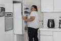 Overweight woman opening a refrigerator at home Royalty Free Stock Photo