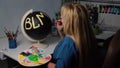 Overweight woman painting BLM sign on the black globe