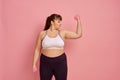Overweight woman shows muscles, body positive
