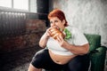 Overweight woman eats sandwich, bulimic