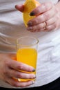 Overweight woman squeezing orange juice into glass