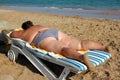 Overweight woman sunbathe on beach Royalty Free Stock Photo