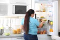 Overweight woman taking sandwich from refrigerator Royalty Free Stock Photo