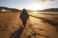 Overweight woman walking alone on the sandy beach shore in a rear view perspective