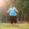 Overweight woman walking on forest trail.