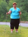 Overweight woman walking on forest trail.