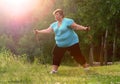 Overweight woman walking on forest trail.