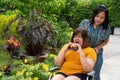 The overweight woman is in a wheelchair. Being eating a burger in which but her friend is not happy because of concern for the Royalty Free Stock Photo