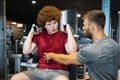 Overweight young man exercising gym with personal trainer Royalty Free Stock Photo