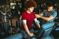 Overweight young man exercising gym with personal trainer Royalty Free Stock Photo