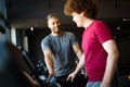 Overweight young man exercising gym with personal trainer Royalty Free Stock Photo