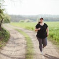 Overweight young woman jogging outdoors