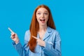 Overwhelmed amused pretty redhead teen girl in nightwear screaming excited and amazed, pointing upper left corner, drop Royalty Free Stock Photo