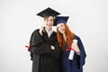 Overwhelmed couple of university graduates happy to receive their diplomas, smiling at camera, redhead girl and boy with