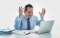 Overwhelmed and desperate mature businessman working with laptop feeling angry and furious at office Royalty Free Stock Photo