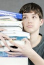 Overwhelmed Teen Holds Stack Of Textbooks