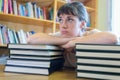 overwhelmed woman leaning on stack books Royalty Free Stock Photo