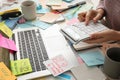 Overwhelmed woman working at messy office desk, closeup