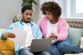 Overwhelmed young african couple using laptop at home