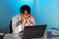 Overwork Concept The man in the office resting his face on his hands and staring at the laptop screen Royalty Free Stock Photo