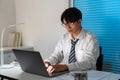 Overwork Concept The man sitting at his desk and focusing on working through his computer laptop Royalty Free Stock Photo