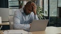 Overworked African American mature man working laptop in office suffer with eye strain exhausted sick fatigued male Royalty Free Stock Photo
