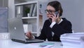 Overworked businesslady answering phonecall, unhappy with news, stressful job