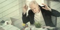 Overworked businessman sitting at a messy desk, geometric pattern Royalty Free Stock Photo