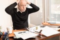 Overworked businessman sitting at a messy desk Royalty Free Stock Photo