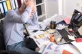 Overworked businessman sitting at a messy desk Royalty Free Stock Photo