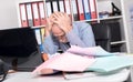 Overworked businessman sitting at a messy desk Royalty Free Stock Photo