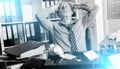 Overworked businessman sitting at a messy desk; light effect Royalty Free Stock Photo