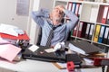 Overworked businessman sitting at a messy desk Royalty Free Stock Photo