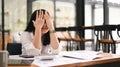 Overworked businesswoman holding covering her face, feeling strong headache, exhausted from overwork or stress at work Royalty Free Stock Photo