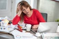 Overworked businesswoman sitting at a messy desk Royalty Free Stock Photo