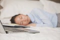 Overworked businesswoman sleeping in the bed with her laptop open Royalty Free Stock Photo