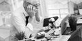 Overworked businessman sitting at a messy desk, geometric pattern Royalty Free Stock Photo