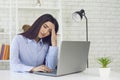 Overworked and tired businesswoman working on laptop computer in home office. Student getting ready for online test Royalty Free Stock Photo