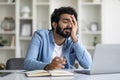 Overworked tired indian male entrepreneur sitting at desk in home office Royalty Free Stock Photo