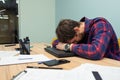 Overworked tired manager sleeping on the desk after a hard day at work. Tired man falls asleep in the workplace. Business startup Royalty Free Stock Photo