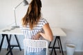 Overworked woman with back pain in office with bad posture Royalty Free Stock Photo